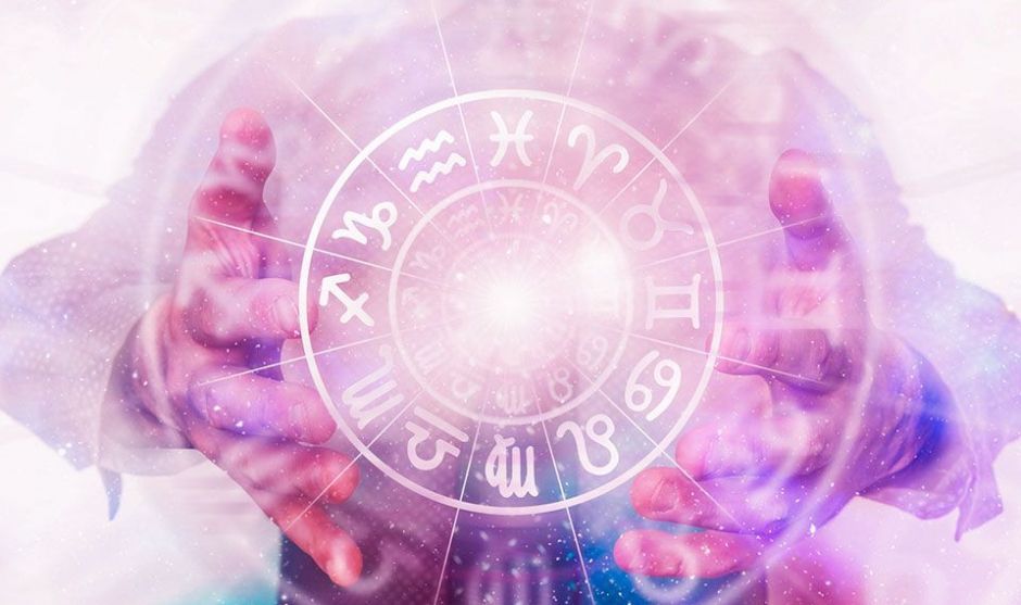 Representación de una carta astral sobre papel antiguo con velas y cristales en ambiente cálido